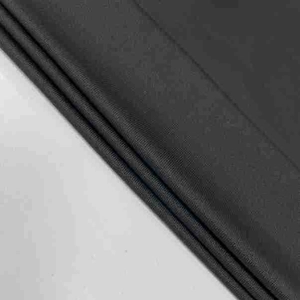 Detailed macro texture of black high-density knit fabric with elegant matte finish drape