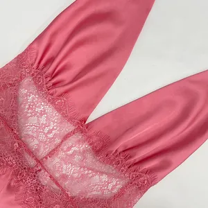 Detail of pink satin fabric with intricate eyelash lace trim and V-neckline texture