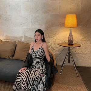 Close-up of zebra print dress with high slit and black leather jacket styling