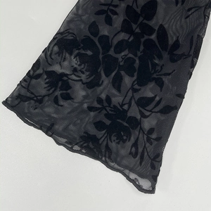 Detail of sheer black chiffon fabric with velvety 3D floral rose flocking texture