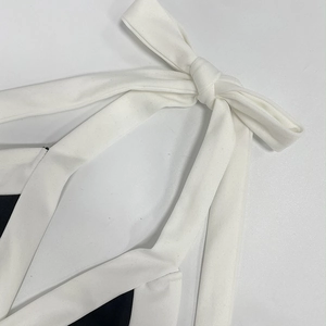 Détail rapproché du nœud papillon blanc du combishort à licou contrasté noir et blanc chic