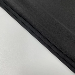 Close-up detail of high-density black lace fabric with elegant matte textile texture