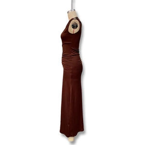 Detail der Seitenraffung und Metallbeschläge an einem eng anliegenden braunen Maxikleid