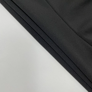 Vue macro d'un tissu tricoté noir montrant des coutures sans couture et une trame élastique