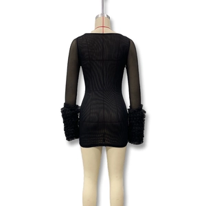 Detail of sheer mesh long sleeves with dramatic ruffled cuffs on a black bodycon dress