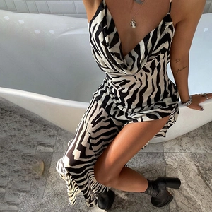 Detail of elegant zebra print satin dress featuring high side slit and cowl neck design