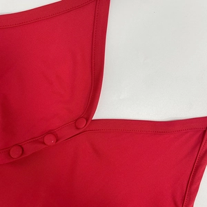 Close-up of red halter dress neckline with three matching fabric-covered buttons