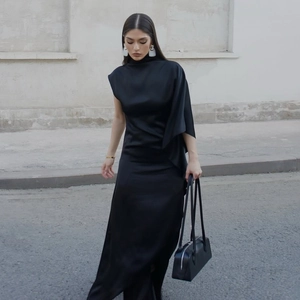 Détail d'une robe longue en satin noir élégante avec un col drapé asymétrique unique