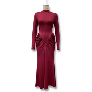 Detail of V-shaped gathering pleats on the waist of a burgundy long-sleeved dress