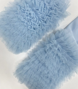 Detail showing ruffled light blue mesh sleeves with layered tulle and pleated design