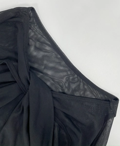 Detailed close-up of semi-transparent black mesh fabric and fine stitching on the dress