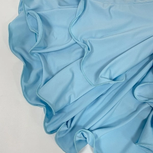 Detail of light blue dress showing smooth fabric texture and ruffled edge stitching