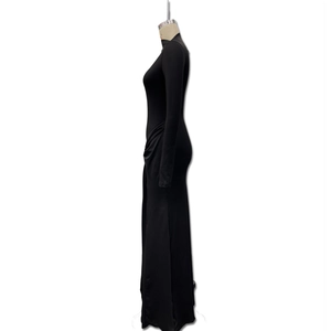 Détail d'une robe longue noire élégante avec manches longues et design plissé sur le côté
