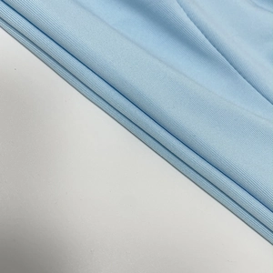 Close-up of light blue ribbed knit fabric showing detailed texture on a slim halter dress