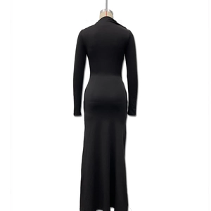 Détail d'une robe longue noire à manches longues avec boucle décorative élégante