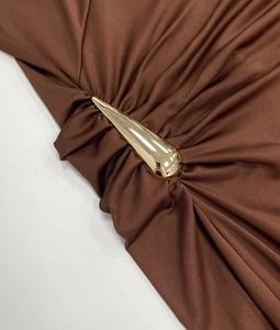 Detail der goldenen Tropfenschnalle am braunen Kleid mit edler Satin-Raffung