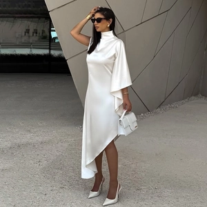 Détail de la robe en satin blanc avec manche asymétrique oversize et col montant