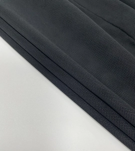Macro shot of dark grey mesh fabric showing breathable piqué texture and fiber detail