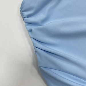 Détail rapproché du tissu côtelé froncé bleu clair montrant la texture et la couture
