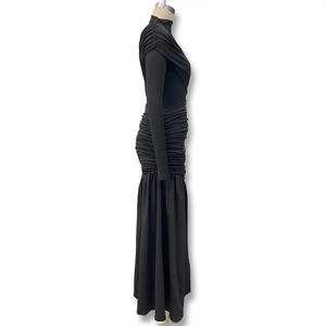 Detail view of the ruched side seams and asymmetrical drapes on the black bodycon dress