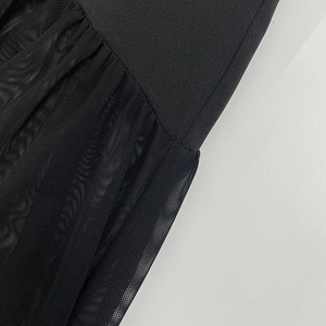 Dettaglio ravvicinato delle cuciture in tulle nero e della trama del vestito