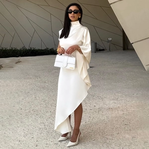 Détail d'une élégante robe asymétrique blanche avec col montant et manches drapées fluides