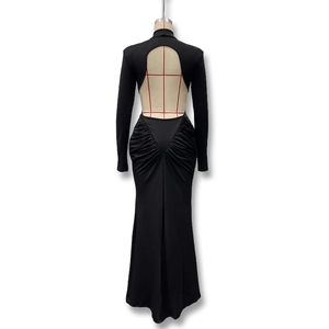 Detail view of the open-back cutout and V-shaped ruched design on black long-sleeve dress
