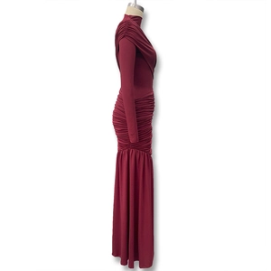 Detail view of the elegant ruched draping and burgundy fabric texture of the slim dress