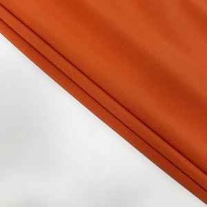 Detail von leuchtend orangem Strickstoff mit dicker Rippstruktur und elastischer Form
