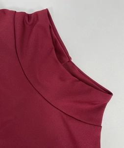 Detailed close-up of vertical ribbed texture and high collar on burgundy knit dress