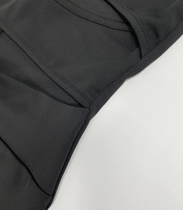 Close-up of high-quality stitching and fabric texture on a black long sleeve jumpsuit