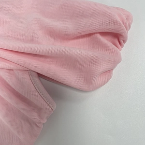 Primo piano dettagliato del tessuto a rete rosa chiaro traspirante con cuciture fini