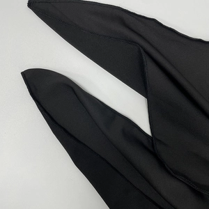 Gros plan du tissu noir montrant la couture de surjet de haute qualité sur le bord de robe