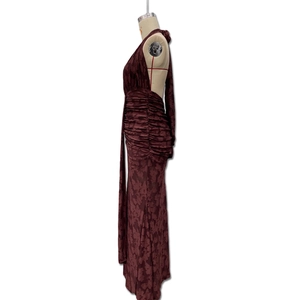 Detail of dark red backless dress showing textured floral pattern and ruched side stitching