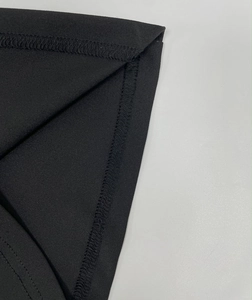 Macro shot showing high-density overlock stitching and smooth black fabric texture