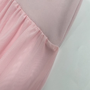Dettaglio macro del tessuto in maglia rosa unito a una trama di tulle a rete pieghettato