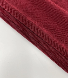 Detailed macro view of the wine red ribbed knit fabric with soft textured vertical stripes