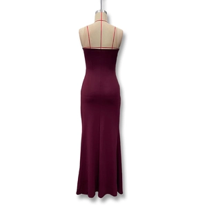 Detail of burgundy slim fit evening dress featuring crisscross back straps and open back