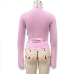 Détail du haut rose à manches longues avec dentelle et design noué à l'arrière du vêtement