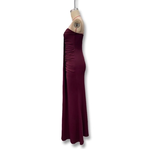 Detail view of burgundy strapless dress featuring side pleated ruffles and slim fit