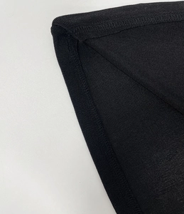 Close-up of black ribbed knit fabric detail with neat stitching and fine vertical texture