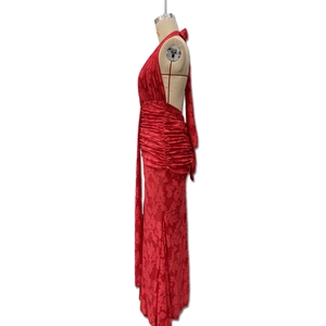 Detail of red backless halter dress showing floral jacquard fabric and ruched textures