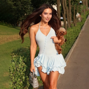 Detail of the light blue halter neck dress featuring front buttons and tiered ruffled hemline