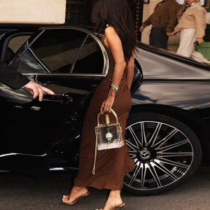Detail der transparenten Acryl-Clutch mit goldener Metallgriff und Kettenriemen auf der Straße