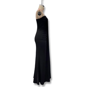 Detail of ruched fabric and side silhouette on a black strapless tube maxi dress