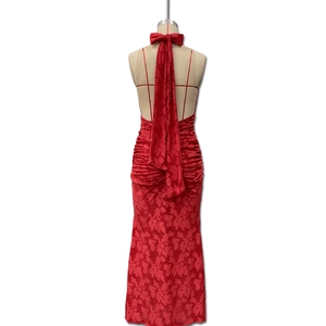 Detail of red floral jacquard fabric on a backless evening dress with long tie straps