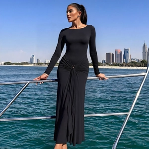 Détail des plis à la taille avec boucle en métal sur robe noire à manches longues