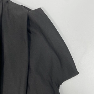 Close-up detail of pleated shoulder design and stitching on black slim-fit dress