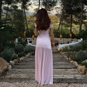 Dettaglio dell'elegante abito lungo rosa con spalle scoperte e pieghe drappeggiate