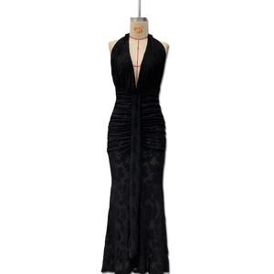 Detailed view of black deep V-neck evening dress with floral lace texture and pleated waist